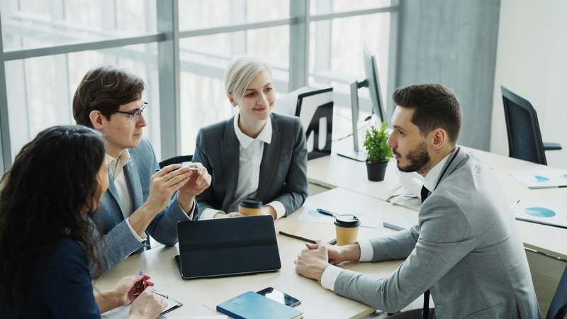 Introverted professional networking comfortably at a small group event with warm lighting and calm expressions